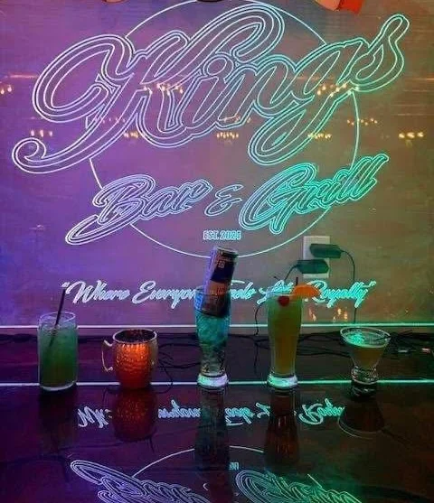 Cocktails in front of the authentic illuminated Kings sign