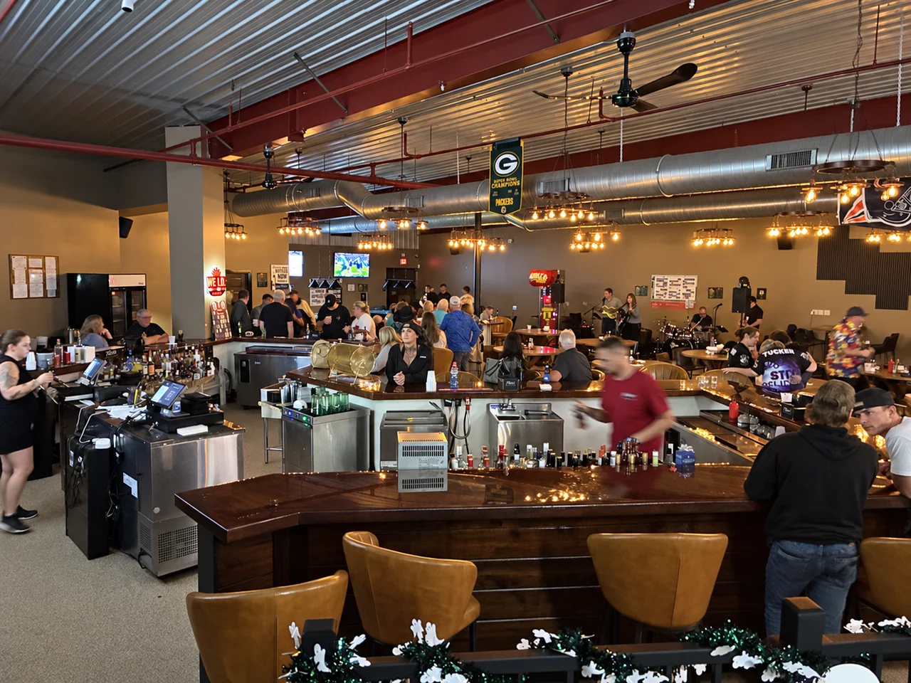 A polished view of guests gathering around the Kings bar during live music