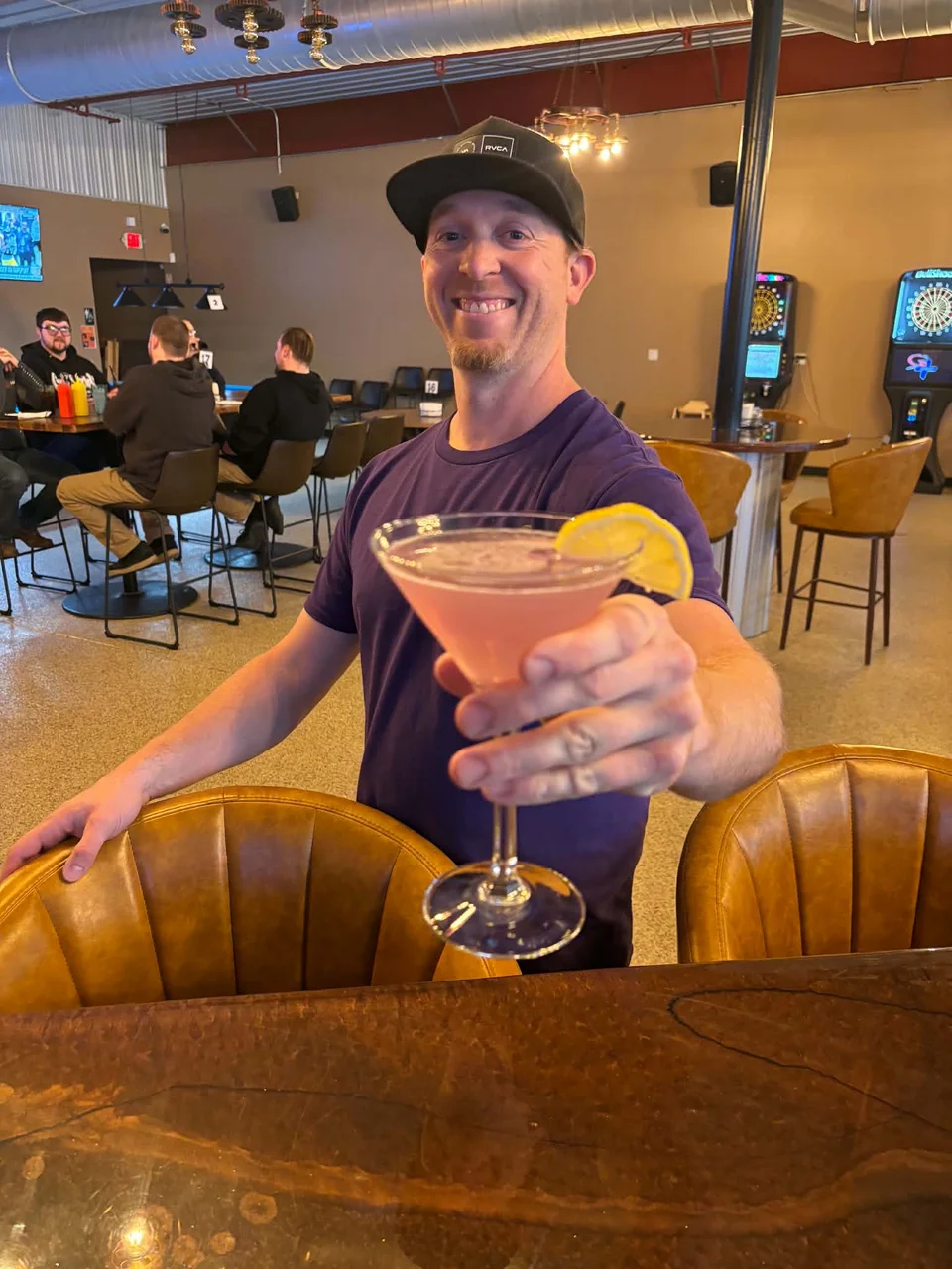 Blake, owner of Kings, holding a pink cocktail in the bar